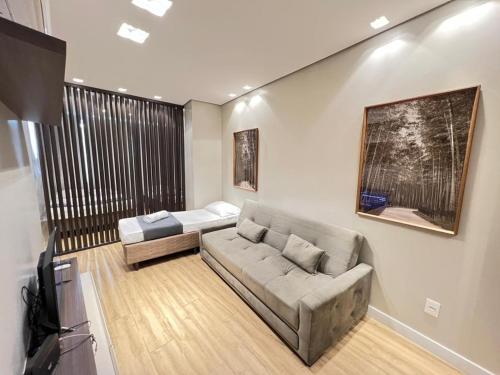 a living room with a couch and a television at LK Santo Agostinho 7 in Belo Horizonte