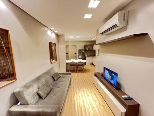 a living room with a couch and a flat screen tv at LK Santo Agostinho 7 in Belo Horizonte