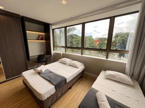 een slaapkamer met twee bedden en twee ramen bij LK Santo Agostinho 7 in Belo Horizonte