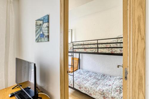 Un dormitorio con una litera y un escritorio con una computadora portátil. en Un séjour a empuriabrava-TERRASSE-VUE MER -CLIME- WIFI PARKING, en Empuriabrava