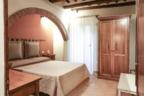 a bedroom with a bed and a wooden door at SweetHome San Martino in San Gimignano