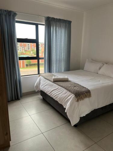 a bedroom with a bed and a large window at Spacious 2 bedroom, 2 bathroom unit in Pretoria