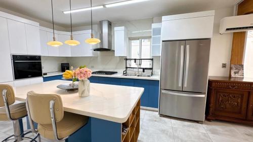 cocina con armarios azules y blancos y nevera en Front Beach Villa, Pool & Basket, 