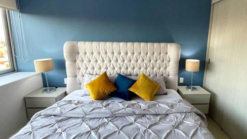 een slaapkamer met een groot wit bed met twee lampen bij 06 Loft Espectacular - Aire Acondicionado, Consulado in Guadalajara