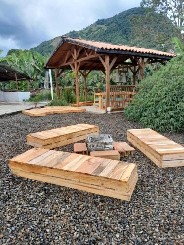 a gazebo with wooden benches and a table at Fresh Start in Jardin