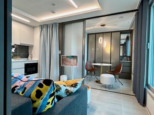 a living room with a couch and a dining room at Ocean Front Apartment in Busan