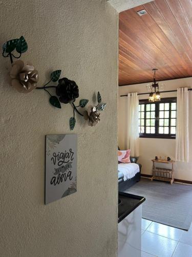 a living room with a bed and a wall at Chalé Verde Oliva in Camanducaia