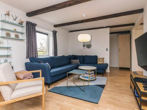 a living room with a blue couch and a table at Cozy Vacation home near Lake in Sakskøbing