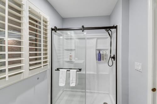 a white bathroom with a shower and a sink at Spacious Rochester Home with Heated Pool and Hot Tub! in Rochester