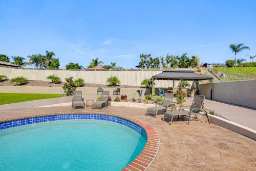 a swimming pool with chairs and a gazebo at Luxe Family Home in Bonita with Private Pool and Spa! in Bonita