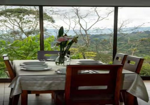 a dining room table with a vase of flowers on it at Paradise Views Awaits, King Bed, Hot-Tub in Quebradas