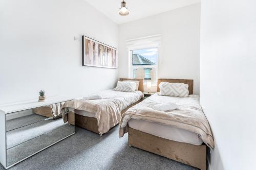 a bedroom with two beds and a desk in it at Modern and Comfy Church Rd Flat 2 with Parking in Newport