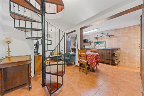 a kitchen and living room with a spiral staircase at Mountain View Cottage in Seixal