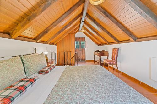 une chambre avec un grand lit avec un plafond en bois dans l'établissement Mountain View Cottage, à Seixal