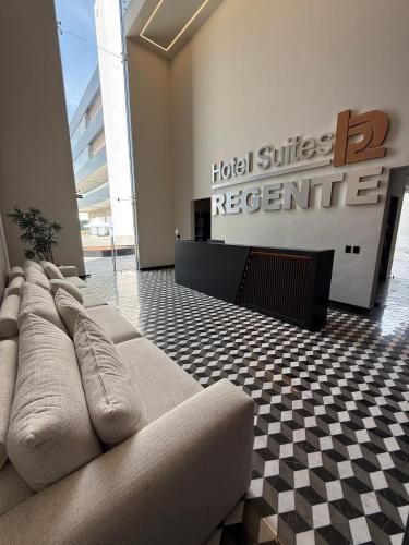a living room with a couch in front of a hotel surface register at Hotel Suites Regente Cholula in Cholula