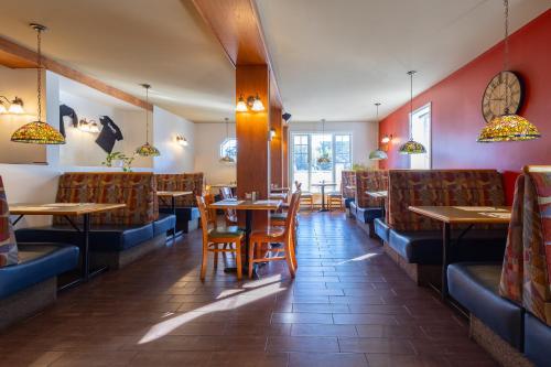 a restaurant with wooden tables and chairs and red walls at Auberge Zacharie in Rivière-à-Pierre