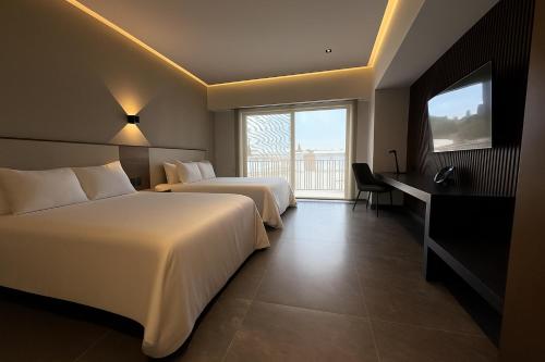 a hotel room with two beds and a television at Hotel Suites Regente Cholula in Cholula