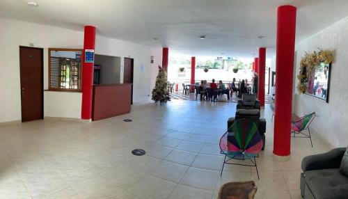 a lobby with red columns and a group of people at Hotel morada del sol 