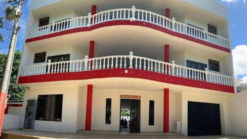 a white and red building with a balcony at Hotel morada del sol 