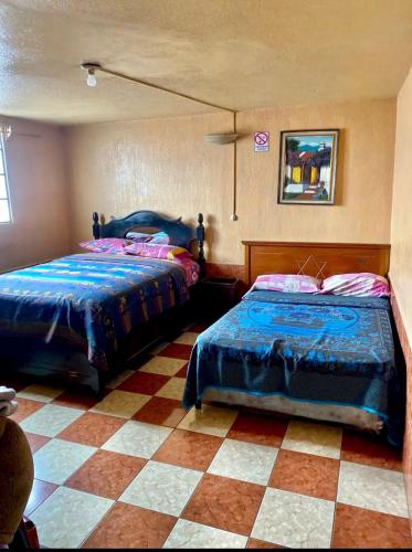 ein Schlafzimmer mit 2 Betten und einem karierten Boden in der Unterkunft Hotel Venus in Las Victorias