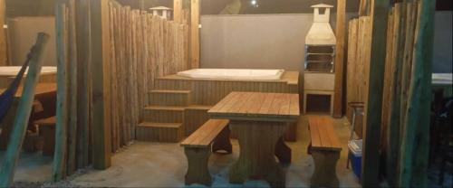 eine Küche mit einem Tisch und Bänken in einem Zimmer in der Unterkunft Apartamento Praia do Sonho - Seu Refúgio Perfeito! in Palhoça