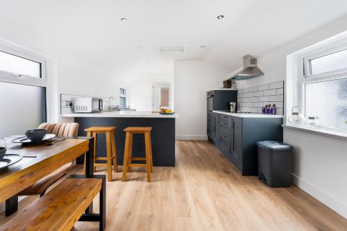 a kitchen and dining room with a wooden table at Modern and Comfy Church Rd Flat 2 with Parking in Newport