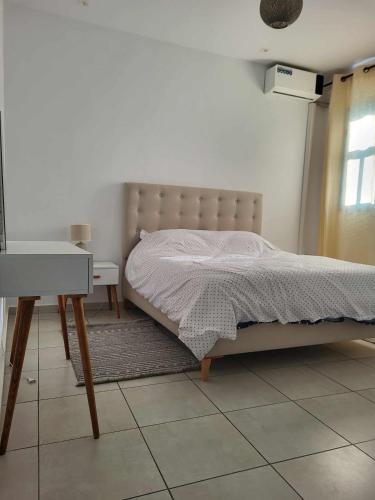 een slaapkamer met een bed, een tafel en een bureau bij Dorra house in La Marsa