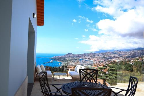 a balcony with chairs and a view of the city at FLH Funchal Bay View Escape with Pool in São Gonçalo