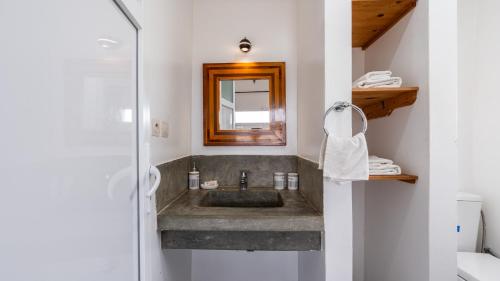 een badkamer met een wastafel en een spiegel bij Auberge Azul Ifni in Sidi Ifni