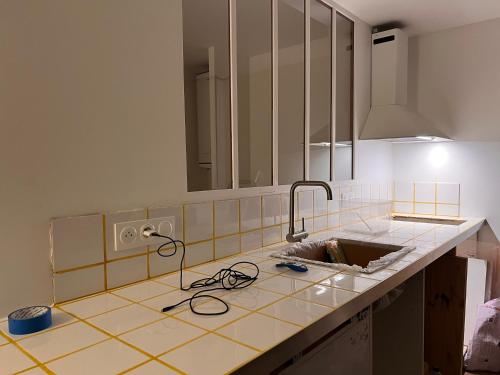 - un comptoir de cuisine avec un évier et un miroir dans l'établissement Nouveau - Élégants appartements rénovés en centre-ville, à Aubenas