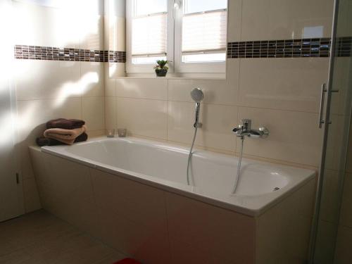 a white bath tub in a bathroom with a window at Villa Kiek Ut in Trent