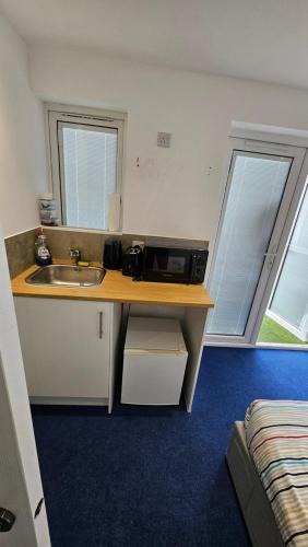 a kitchen with a sink and a microwave on a counter at Restful Place in Wainscot