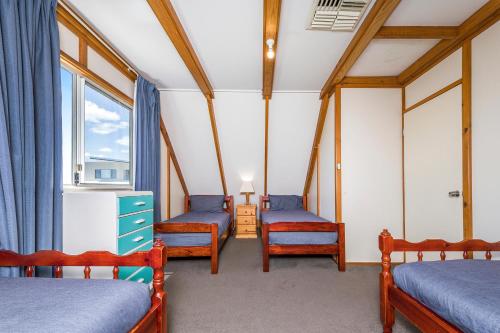 a room with three beds and a window at Ocean Vista Large Modern Home With Ocean Views in Guilderton