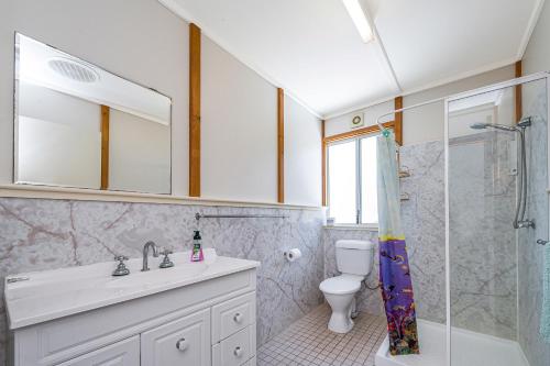 Un baño con lavabo, inodoro y ducha. en Ocean Vista Large Modern Home With Ocean Views, en Guilderton