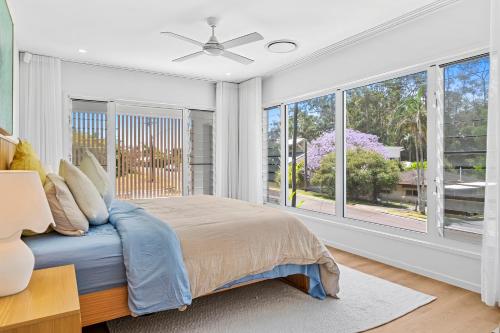 une chambre avec un lit et une grande fenêtre dans l'établissement Luxe at Alex - Your Coastal Retreat Awaits, à Alexandra Headland