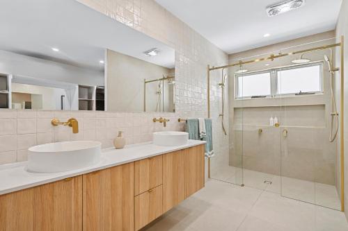 une salle de bain avec deux lavabos et une douche dans l'établissement Luxe at Alex - Your Coastal Retreat Awaits, à Alexandra Headland