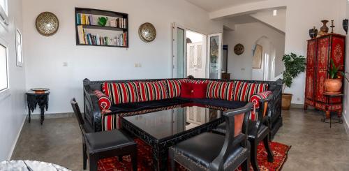 een woonkamer met een bank en een glazen tafel bij Auberge Azul Ifni in Sidi Ifni