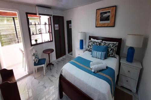 a bedroom with a bed with blue pillows at Puerto Plata Home in San Felipe de Puerto Plata