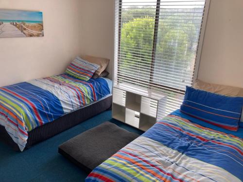 a bedroom with two beds and a large window at 93 Atherton in Evergreen