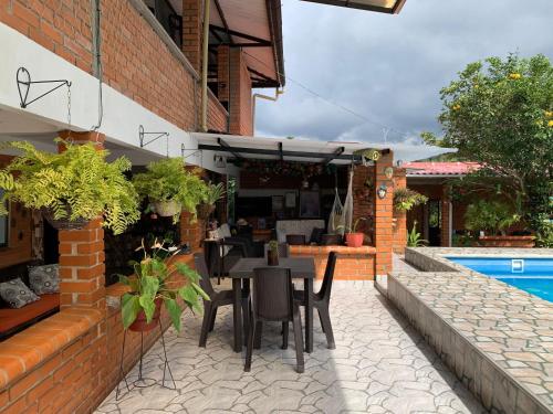 a patio with a table and chairs next to a pool at Villa Pospon in Buga