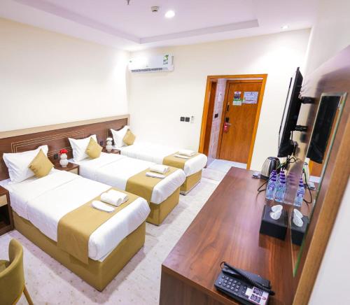 a hotel room with two beds and a television at فندق بارك الياس in Aţ Ţunḑubāwī