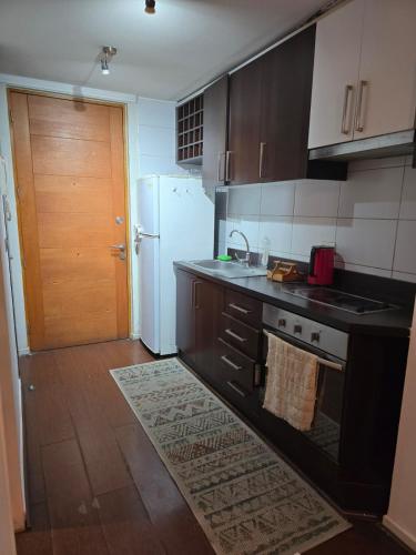 eine Küche mit einem weißen Kühlschrank und einer Spüle in der Unterkunft H de Santiago in Santiago