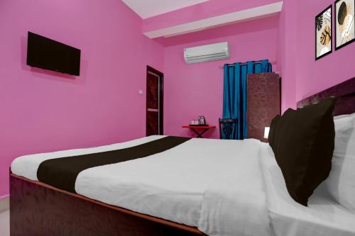 a bedroom with pink walls and a bed at Hotel O Patliputra Railway Station Formerly Rameshwaram Guest House in Dānāpur
