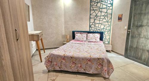 a bedroom with a bed with a pink bedspread and a table at Le Havre de Paix in Nabeul