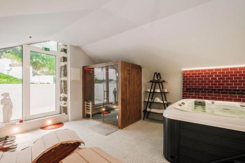 een badkamer met een bad en een glazen douche bij Palacete do Guerreiro SPA & Country House in Oliveira do Hospital