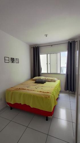 a bedroom with a bed with a yellow blanket at Quarto privativo in São-José-do-Ribamar