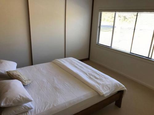 une chambre avec un lit blanc et une fenêtre dans l'établissement Centre31, à Evergreen