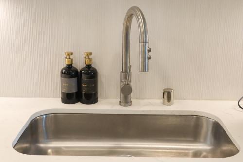 two bottles of wine sitting on a kitchen sink at Bright & Cozy Getaway with Pool Free Parking 10 mins Disneyland in Tustin