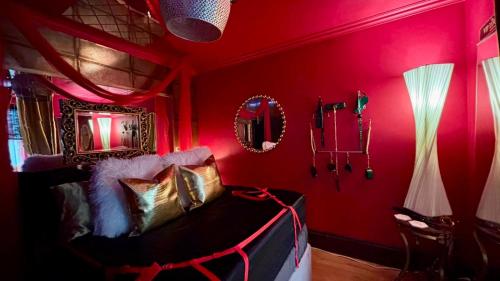 een kamer met rode muren en een bank in een kamer bij Fantastic Naughty Corner in Brighton & Hove