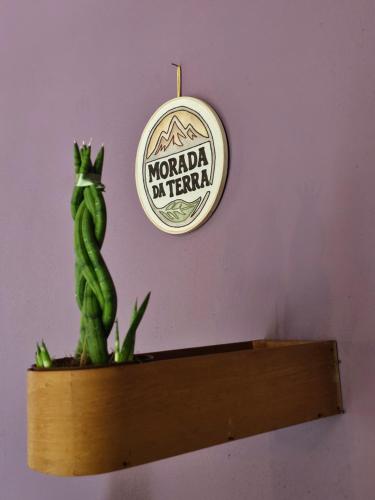 a plant on a shelf with a clock on a wall at Morada da Terra Lapinha da Serra in Santana do Riacho